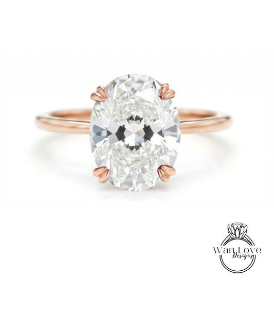 A close-up of a diamond engagement ring with a large oval-shaped diamond set in a rose gold band.