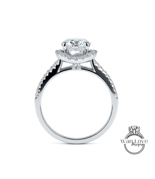 A silver engagement ring with a large central diamond and smaller diamonds on either side of the halo.
