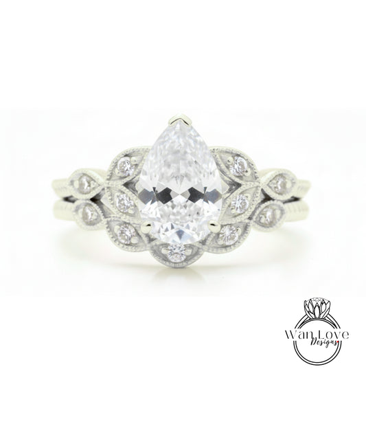 A close-up of a diamond engagement ring with a large pear-shaped diamond at the center, surrounded by smaller diamonds.