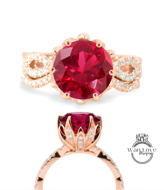 a beautiful pink gold ring with a large, round, red gemstone at the center. The ring has a delicate floral design around the gemstone and is adorned with small diamonds.