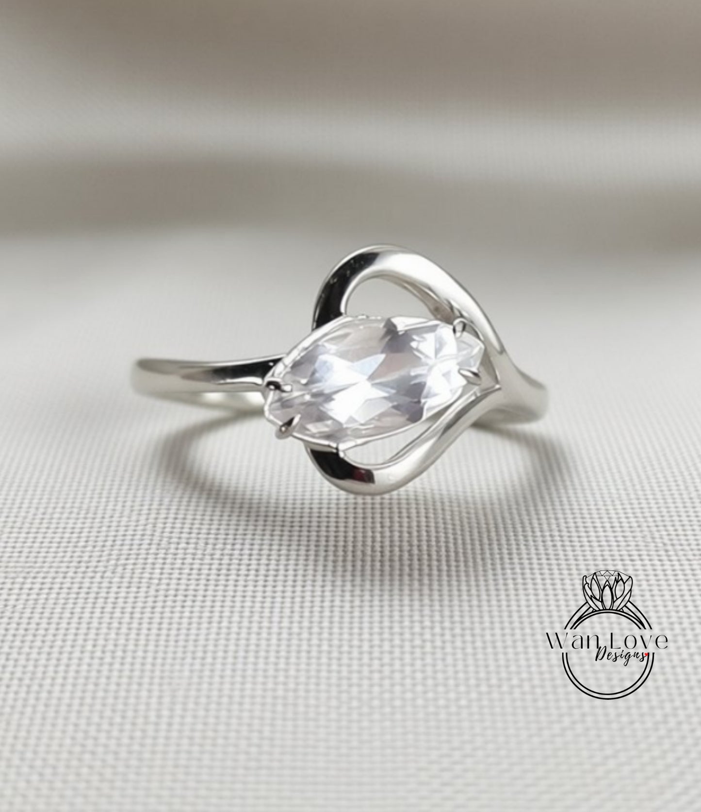 A silver ring with a large, clear gemstone set in a heart-shaped design.