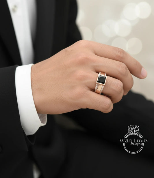 A close-up of a person's hand wearing a gold ring with a black gemstone.