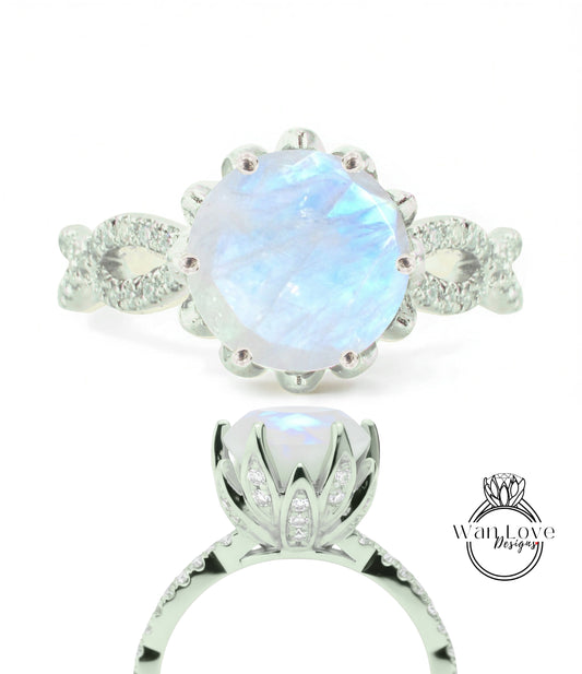 A silver ring with a large moonstone as the centerpiece, surrounded by smaller diamonds.