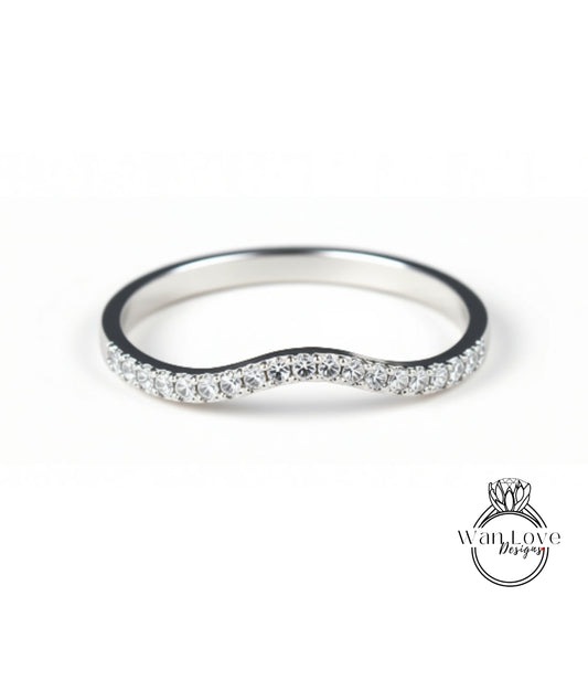A silver ring with a wavy band and small diamonds set in it.