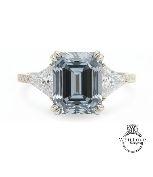 A stunning engagement ring featuring a large, rectangular-shaped blue gemstone set in a silver band, with two smaller diamonds on either side.