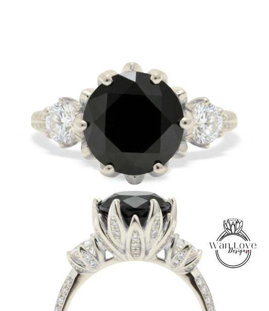 a silver ring with a large black gemstone, likely a diamond, as the centerpiece. The ring is adorned with multiple smaller diamonds set in the floral design.