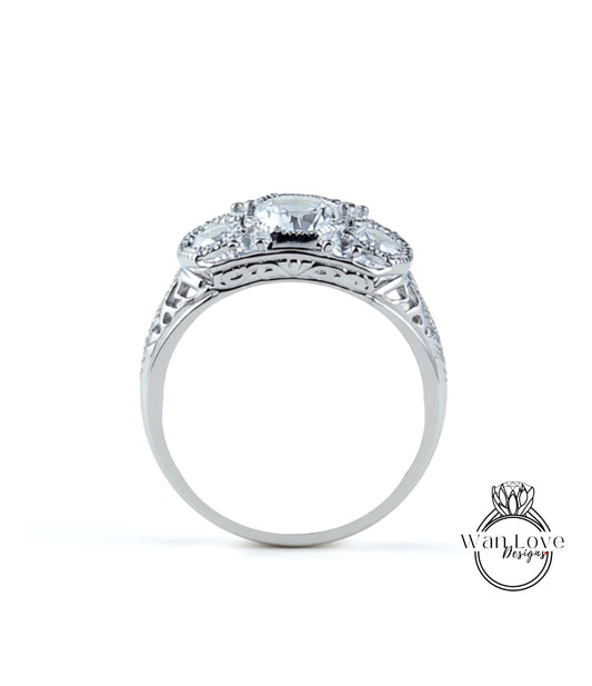 A silver ring with a large central diamond surrounded by smaller diamonds, showcasing intricate metalwork and detailing.