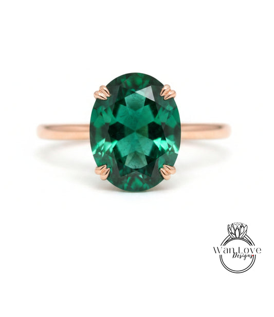 a large oval-shaped green gemstone set in a rose gold ring.