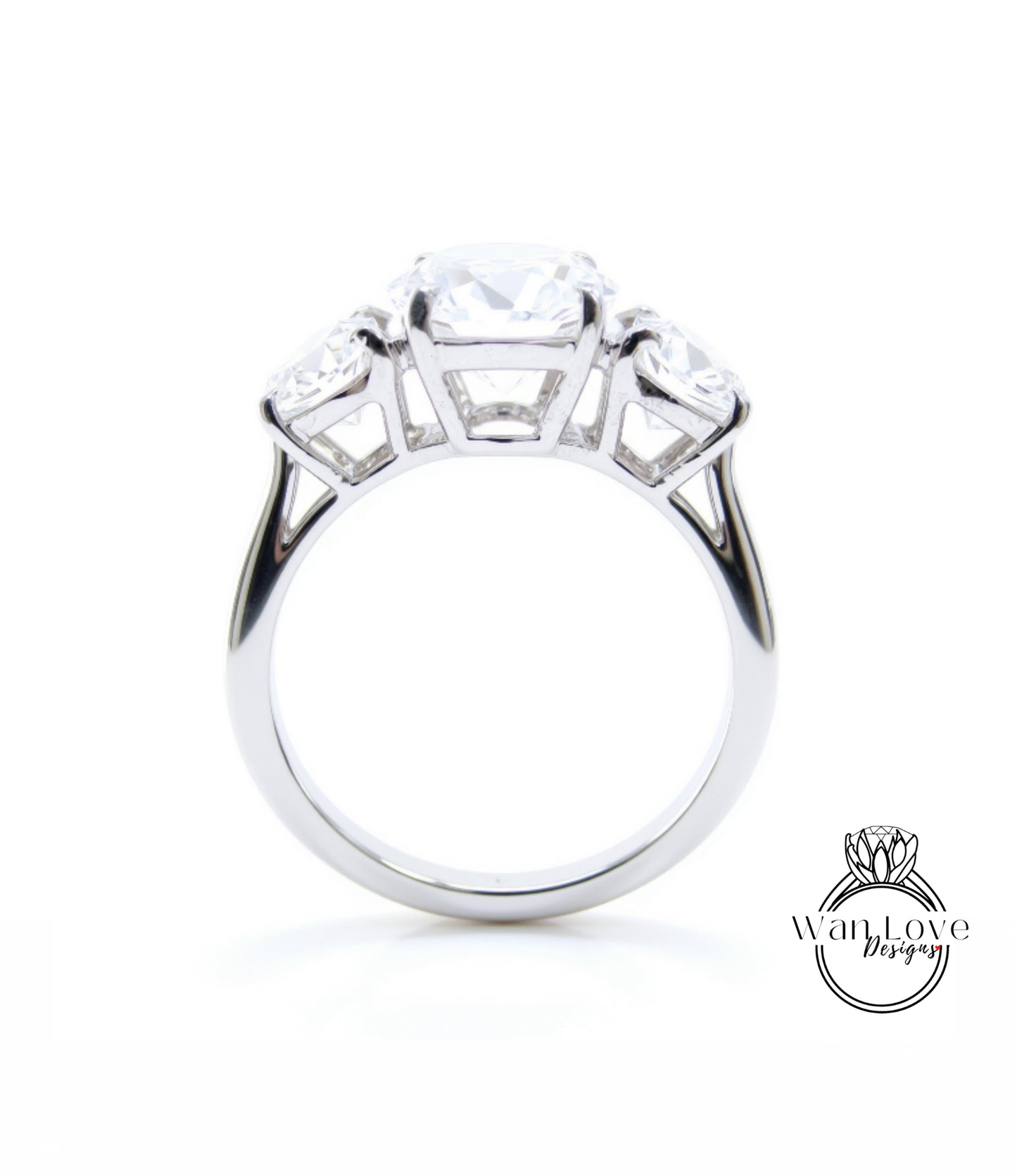 A silver engagement ring with a large central diamond surrounded by smaller diamonds on either side.
