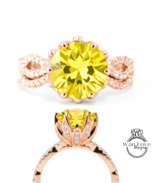 a beautiful yellow diamond ring with a large central diamond surrounded by smaller diamonds on either side. The ring is set in a rose gold band with a delicate floral design.