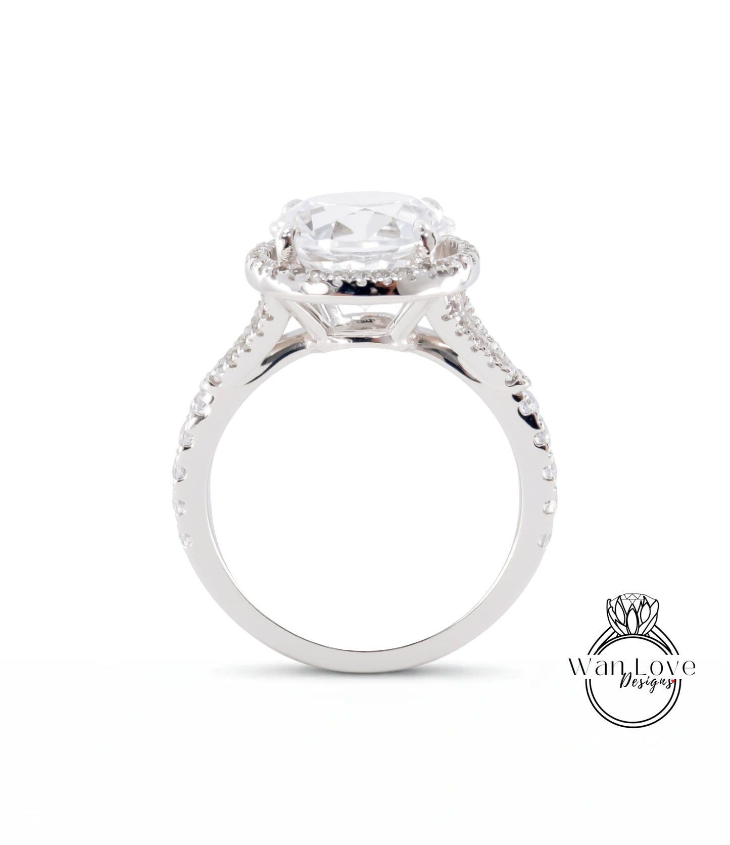 A close-up view of a silver engagement ring with a large central diamond and a halo of smaller diamonds around it.