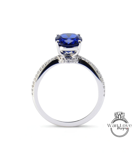 A silver ring with a large blue gemstone, likely a sapphire, at the center.
