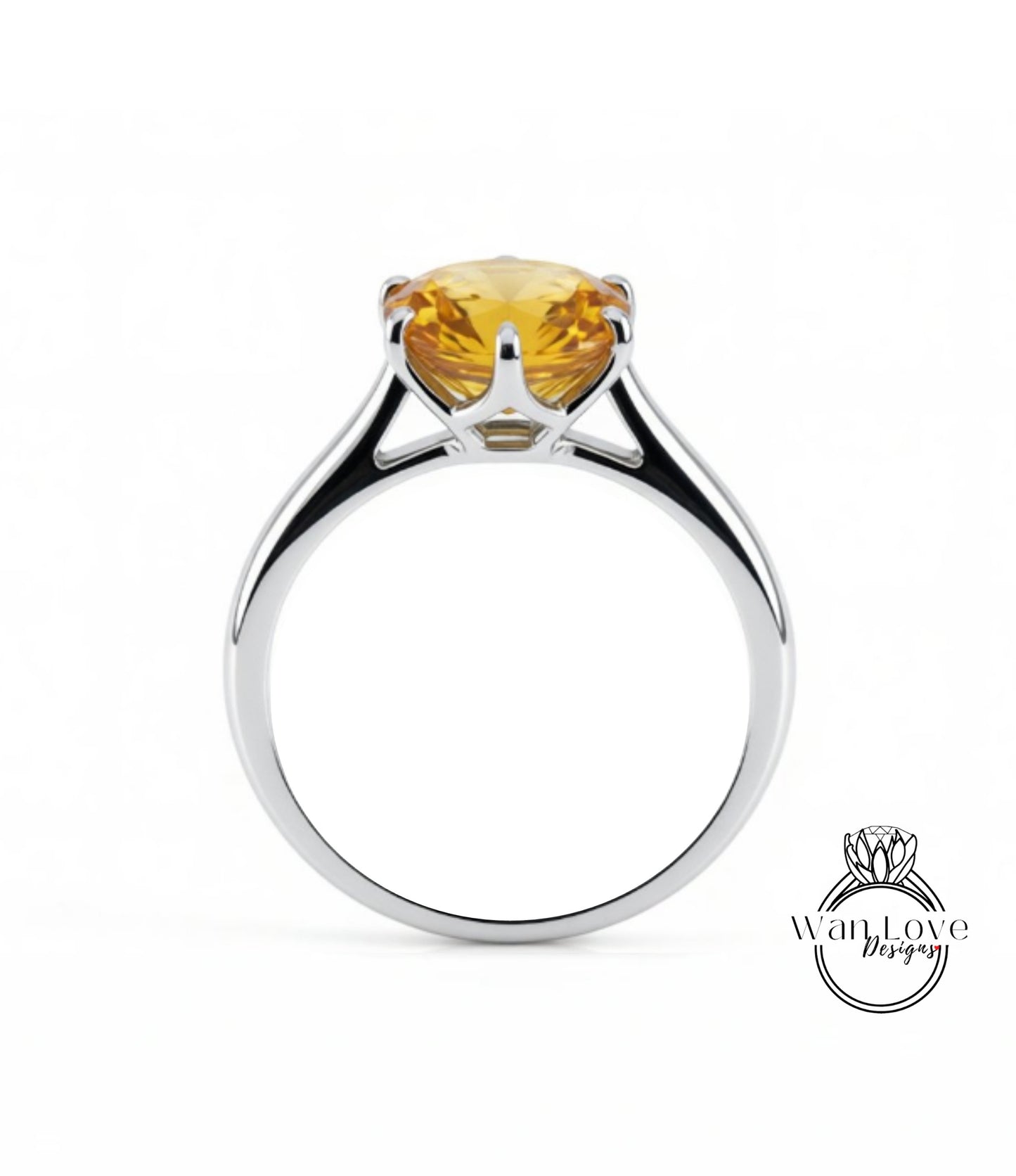A silver ring with a large yellow gemstone, likely a diamond, set in the center.