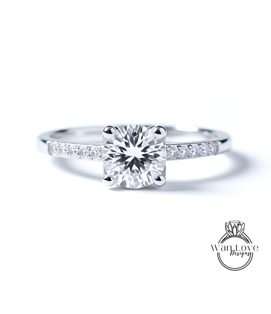 A close-up view of a diamond engagement ring with a large central diamond surrounded by smaller diamonds set in a silver band.