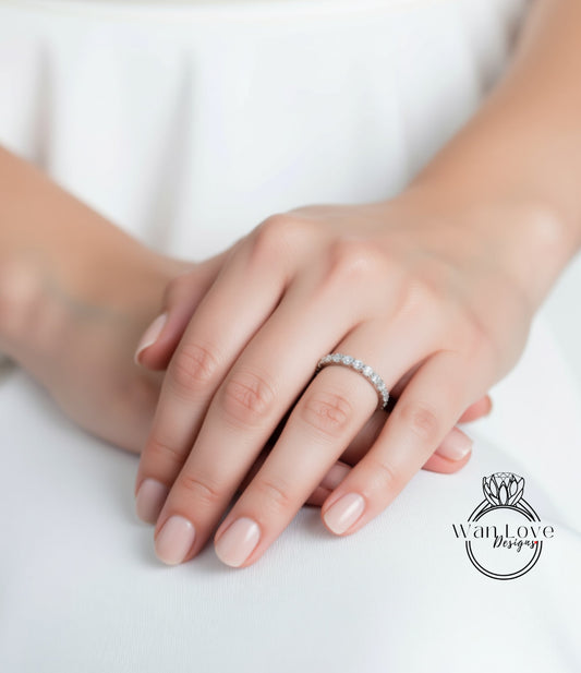 A close-up of a person's hand wearing a diamond ring, with the ring's band visible.
