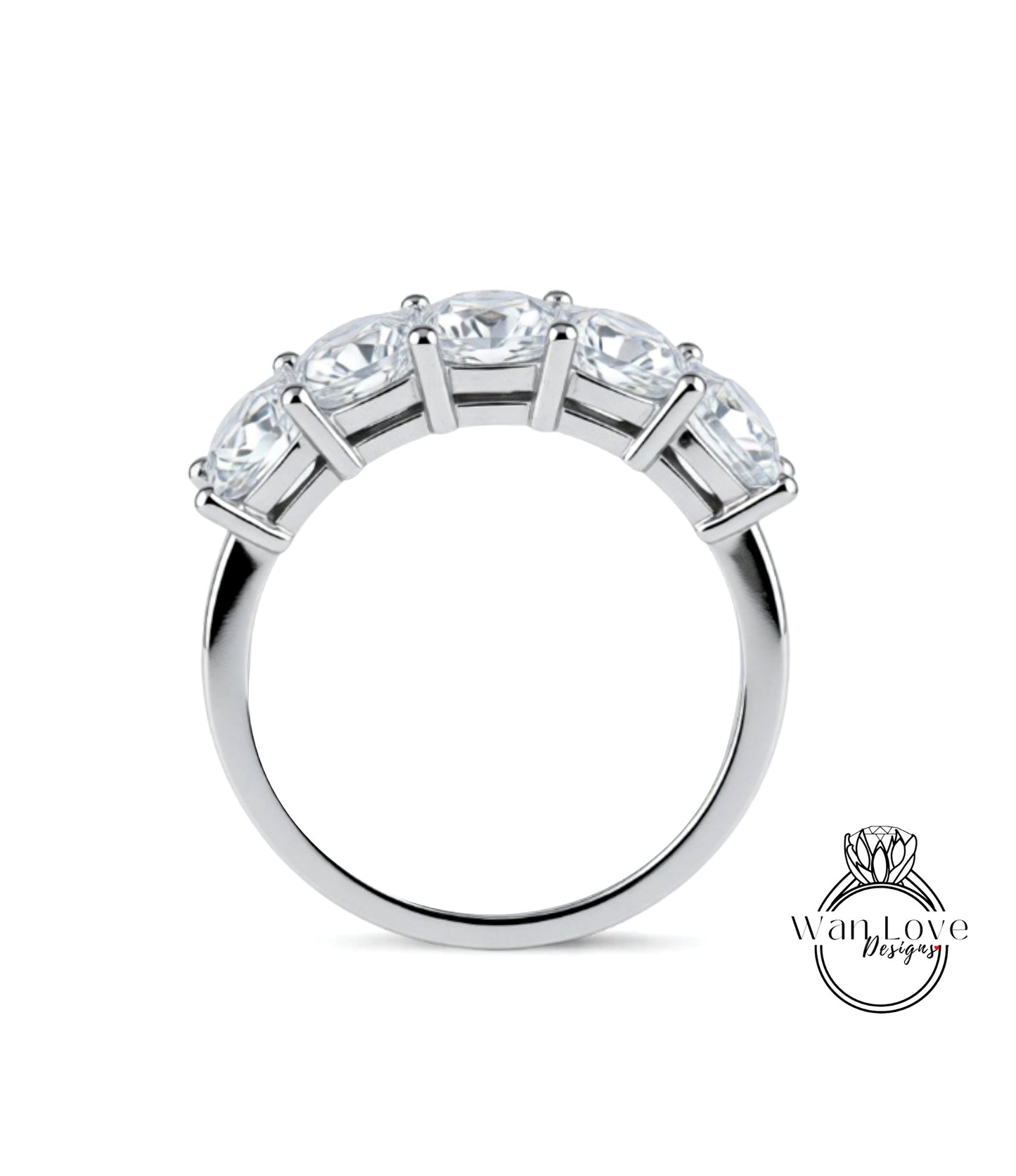 A silver ring with a row of five clear gemstones set in the band.