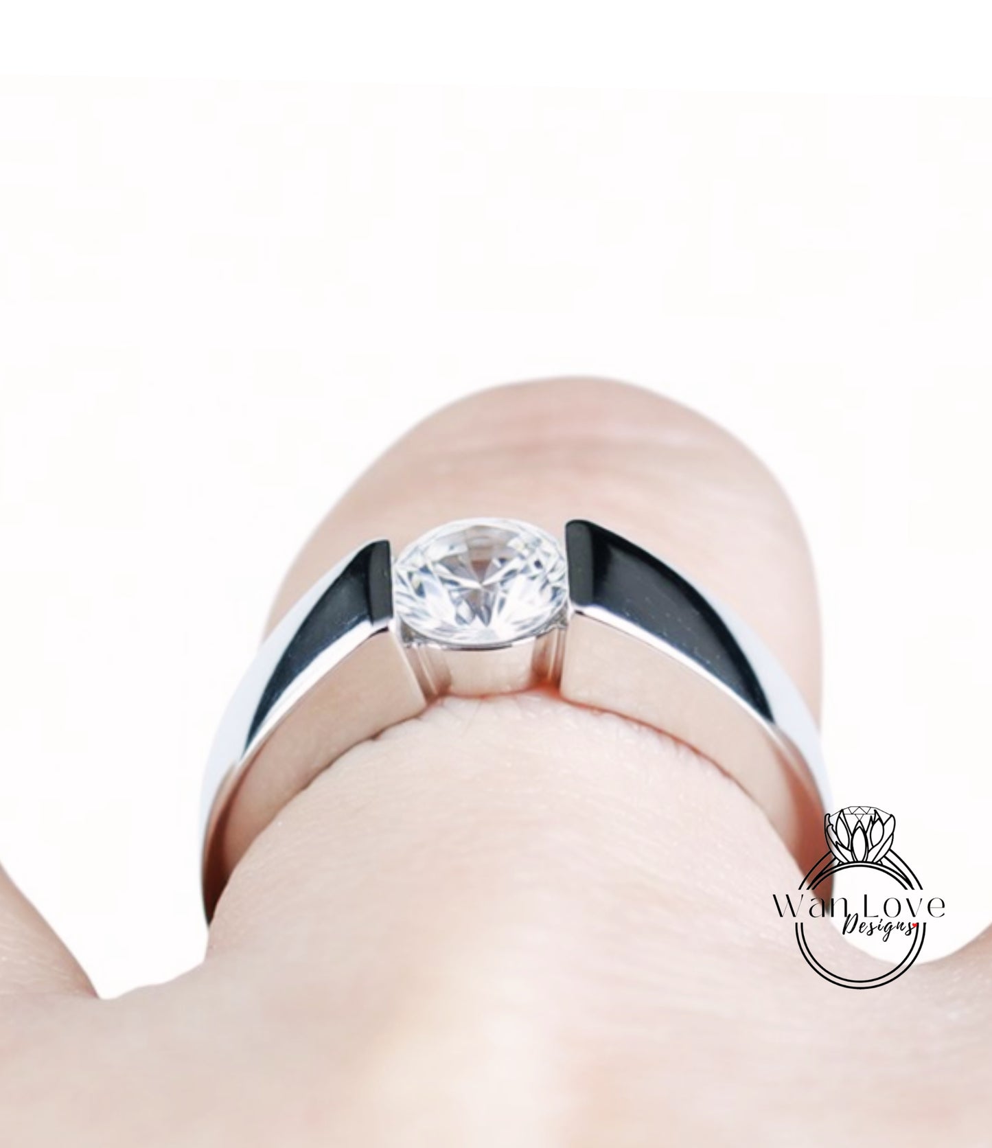 A close-up view of a person's hand wearing a silver ring with a large, clear gemstone.