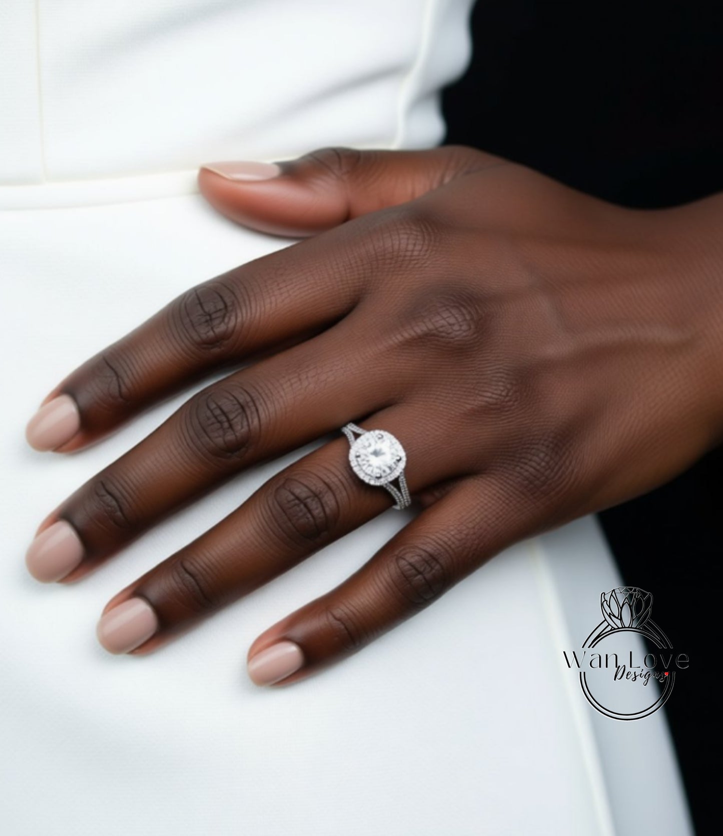 A close-up of a hand wearing a diamond engagement ring.
