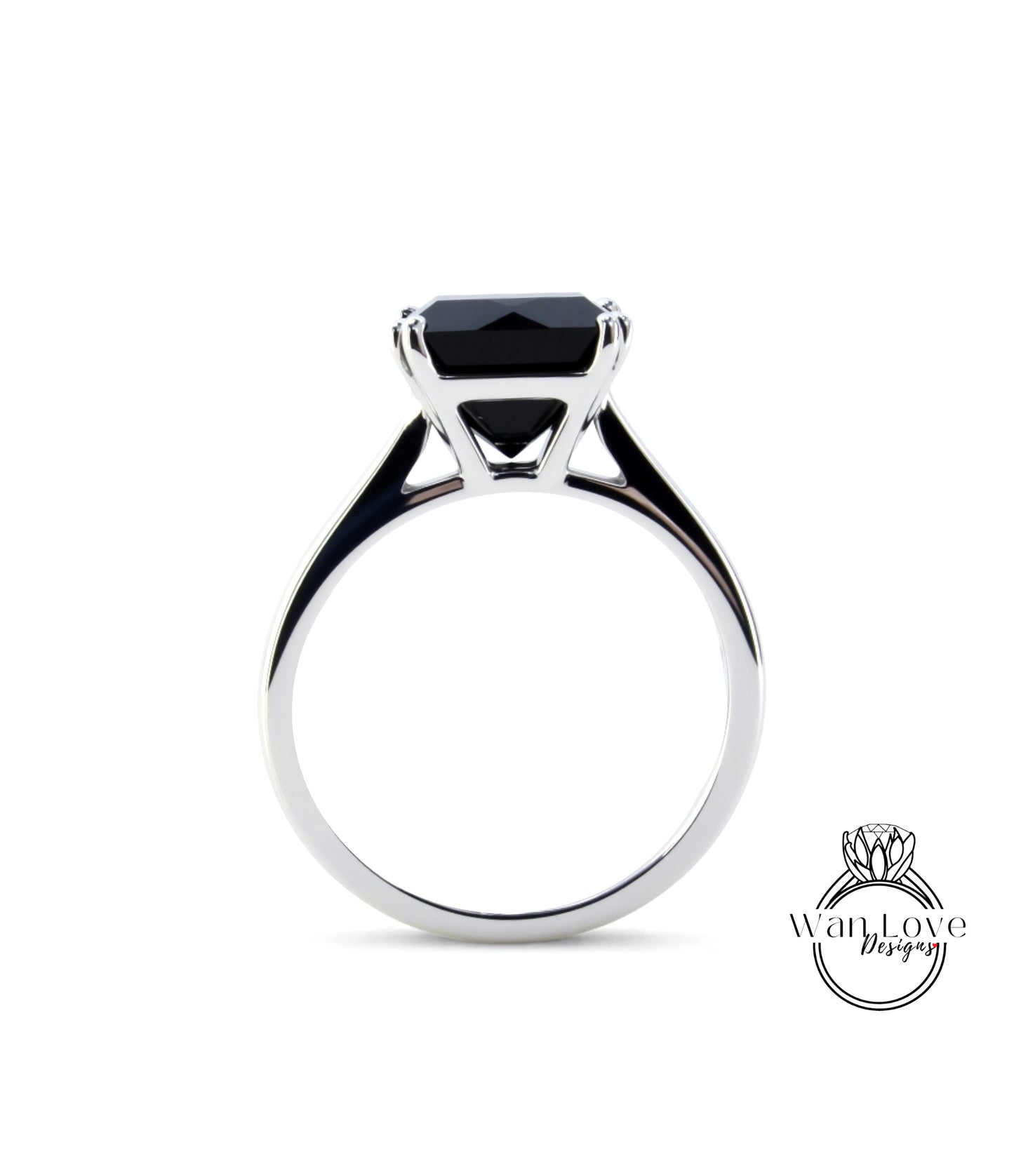 A silver ring with a large black gemstone, likely a diamond, set in the center.