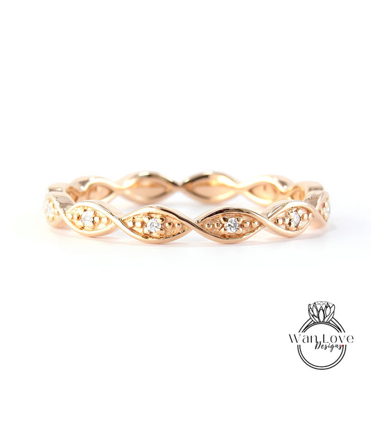 A gold ring with a twisted design and small diamonds set in the center.