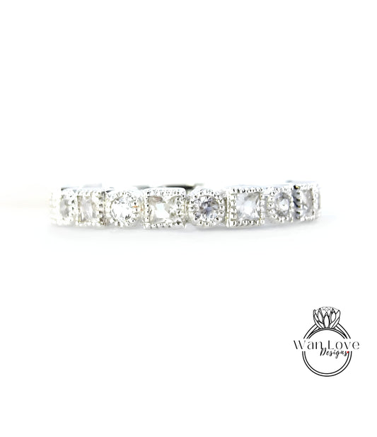 A silver band with a row of clear gemstones, likely diamonds, set in a decorative pattern.