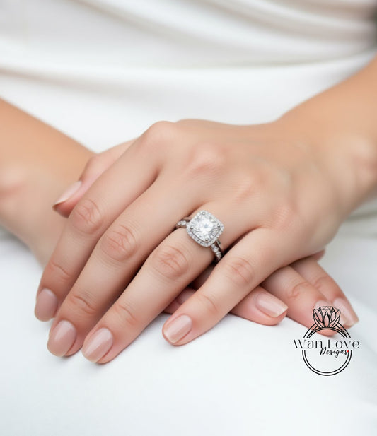 A close-up of a person's hand wearing a large diamond engagement ring.