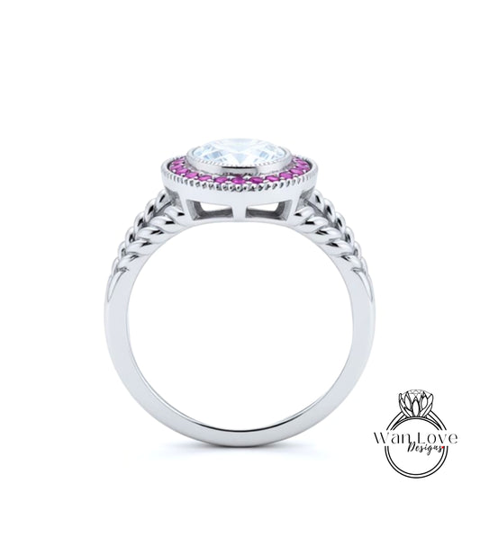 A silver ring with a large central gemstone surrounded by smaller stones, and a decorative band with braided elements.