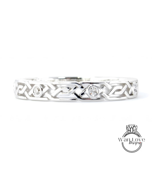 A silver band with an intricate Celtic knot design and two small diamonds set in the center.
