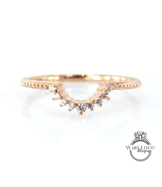 A rose gold ring with a diamond-encrusted band and a row of small diamonds set in the center.