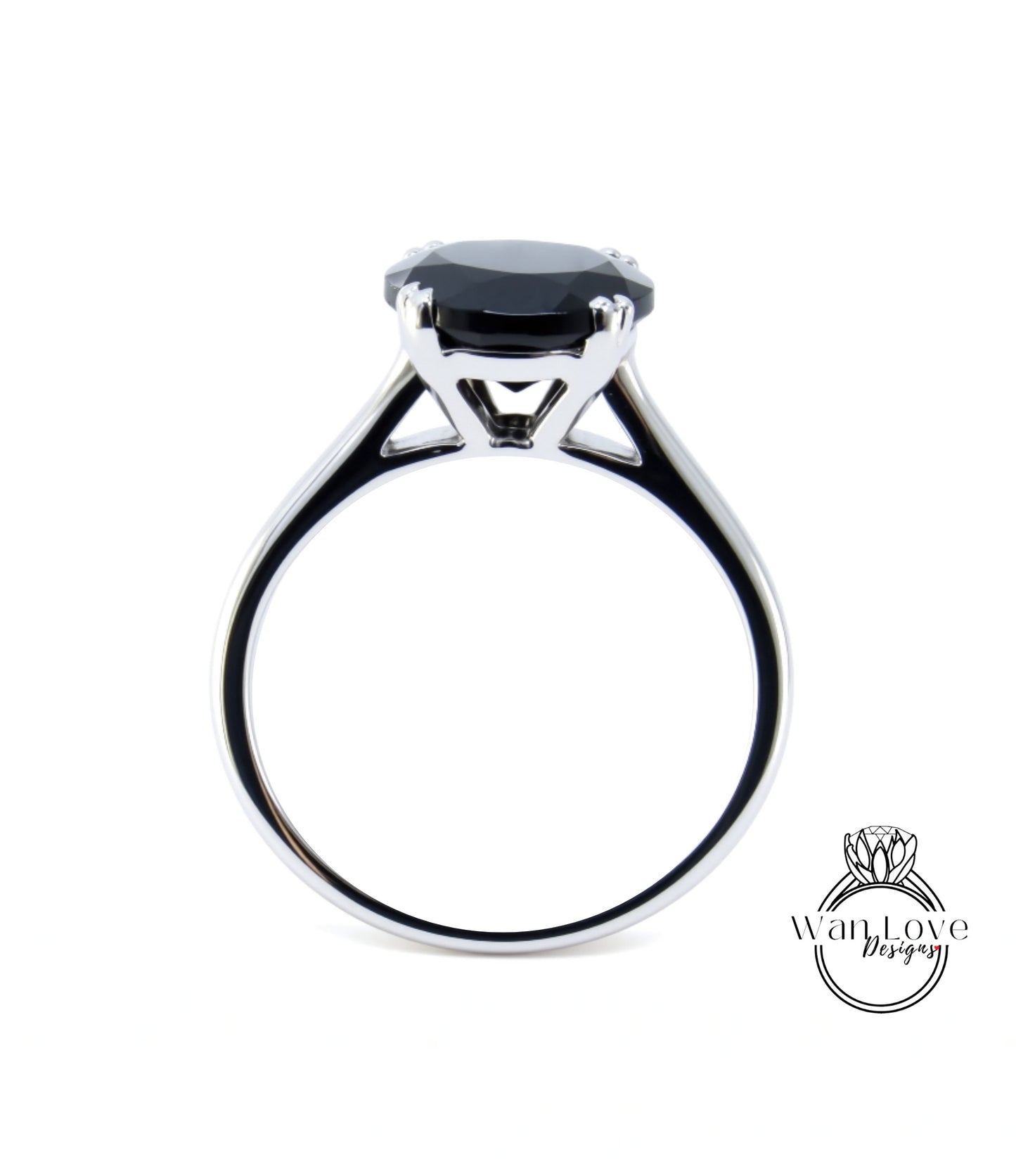 A silver ring with a large black gemstone, likely a diamond, set in the center.