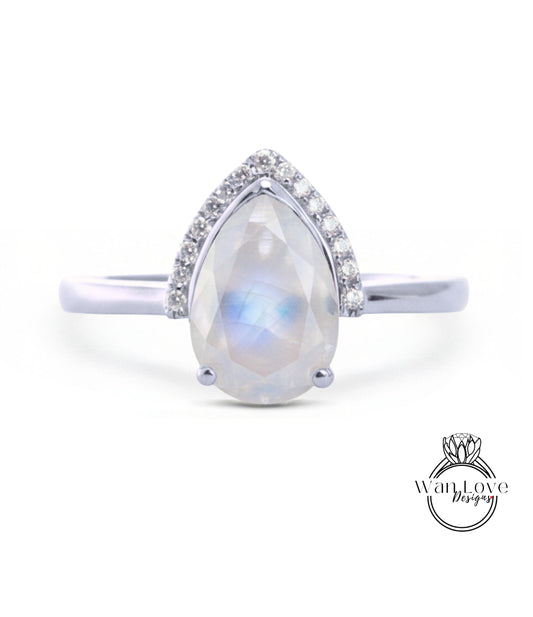 A silver ring with a large, clear gemstone in the center, surrounded by smaller diamonds.