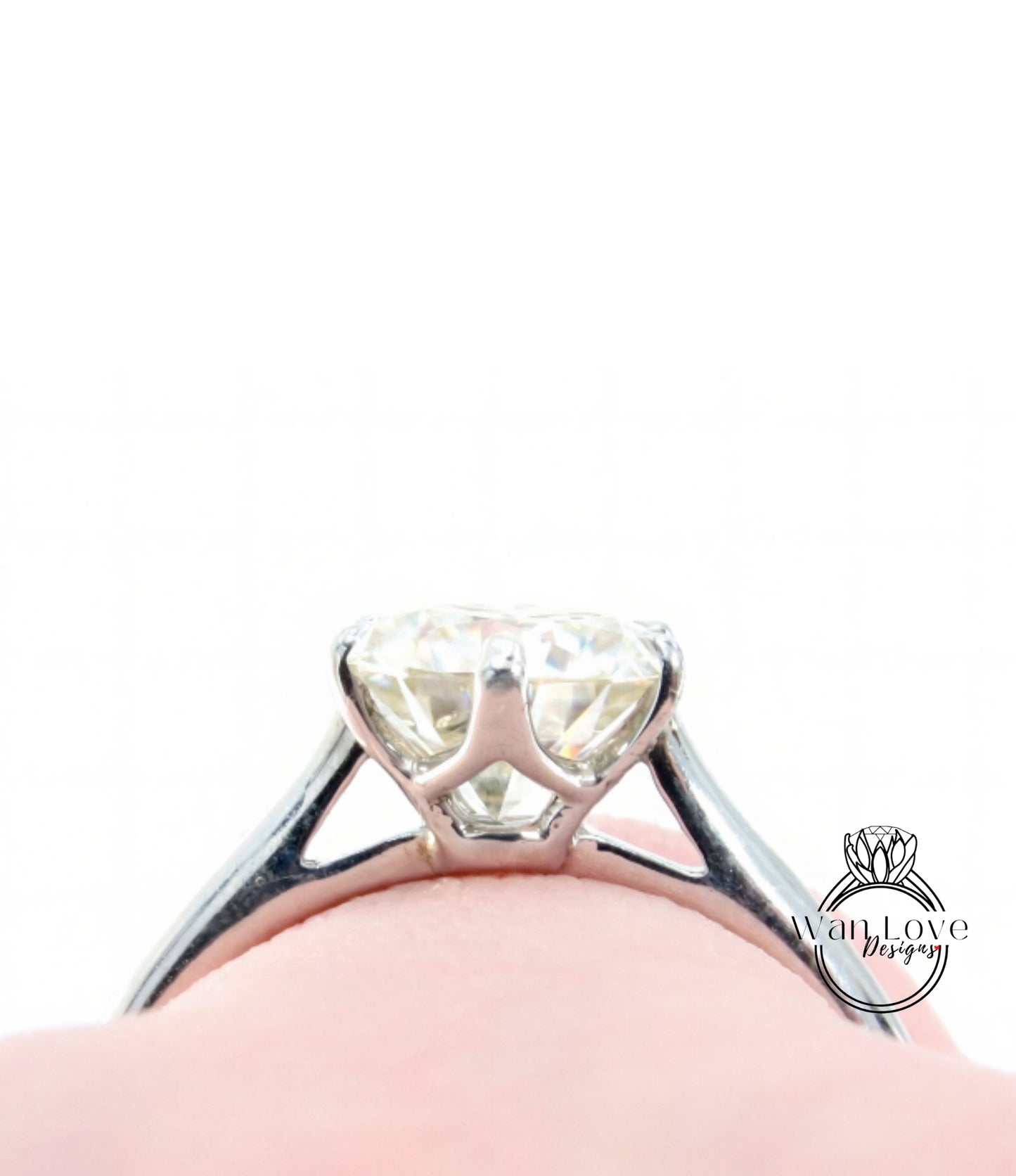 A close-up view of a diamond engagement ring on a person's finger, showcasing the sparkling center stone.