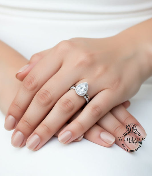 A close-up image of a person's hands wearing a diamond engagement ring.