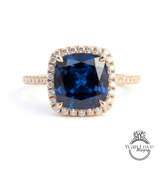 A large blue gemstone set in a gold ring with a halo of smaller diamonds around the edge.
