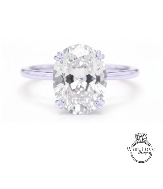A close-up of a diamond engagement ring with a large oval-shaped diamond set in a silver band.