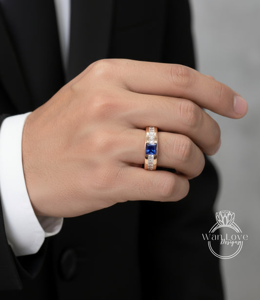 A close-up of a person's hand wearing a gold ring with a blue gemstone.