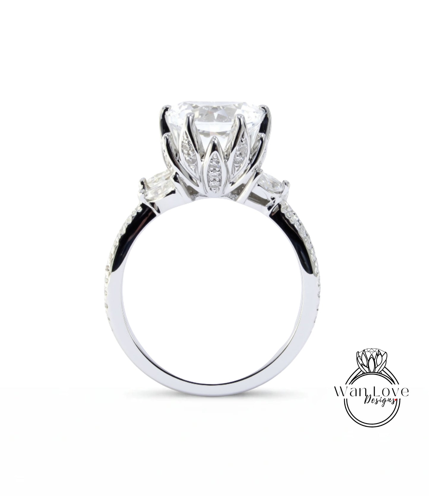 A close-up view of a silver engagement ring with a large central diamond surrounded by smaller diamonds on either side.