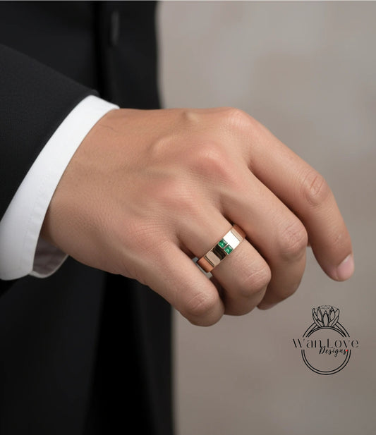 A close-up of a person's hand wearing a gold ring with a green gemstone.