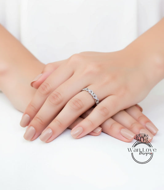 A close-up image of a person's hands resting on a white surface, with a ring visible on one of the fingers.