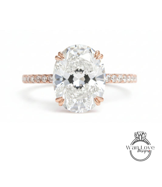 A close-up of a diamond engagement ring with a large oval-shaped diamond set in a rose gold band.