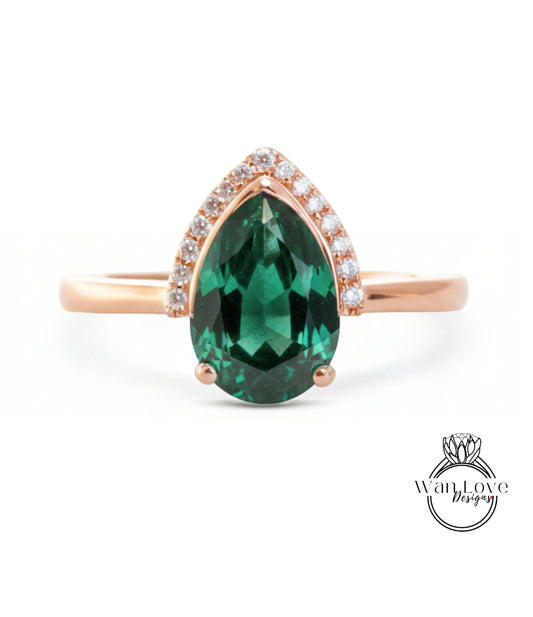 A gold ring with a large, green gemstone in the center, surrounded by smaller diamonds.
