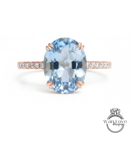 A beautiful blue gemstone ring with a rose gold band and small diamonds.
