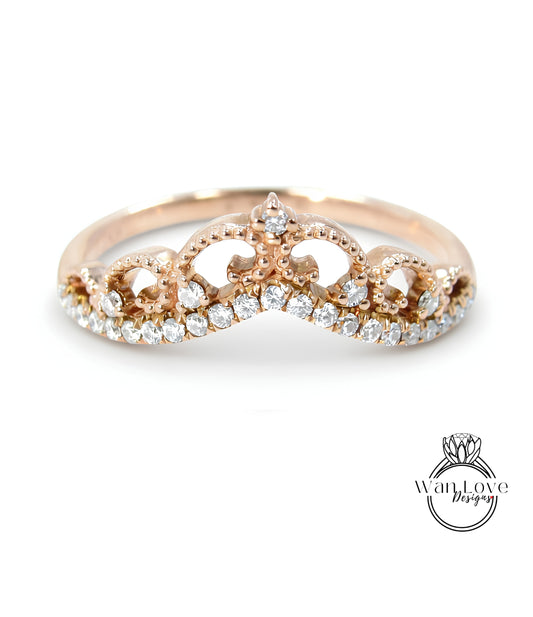 A gold ring with a decorative crown-like design and sparkling diamonds.