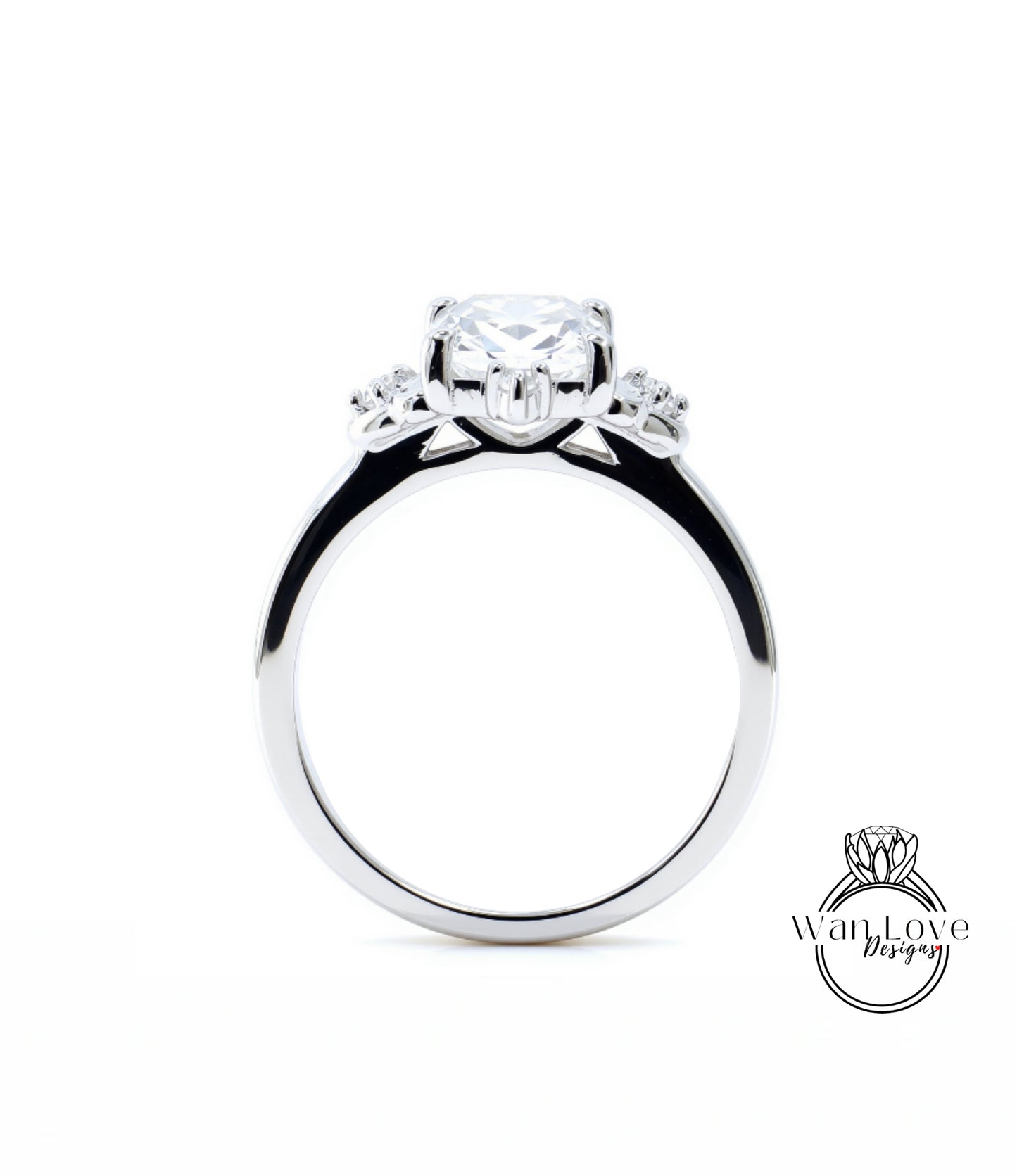 A close-up view of a silver engagement ring with a large central diamond surrounded by smaller diamonds on either side.