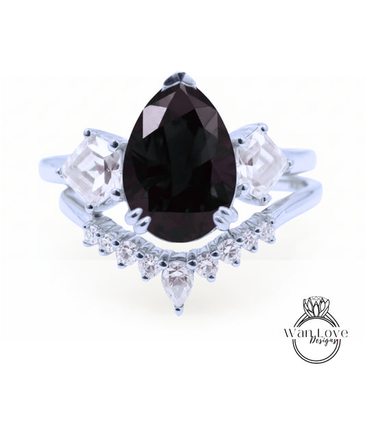A silver ring with a large black gemstone at the center, surrounded by smaller diamonds.