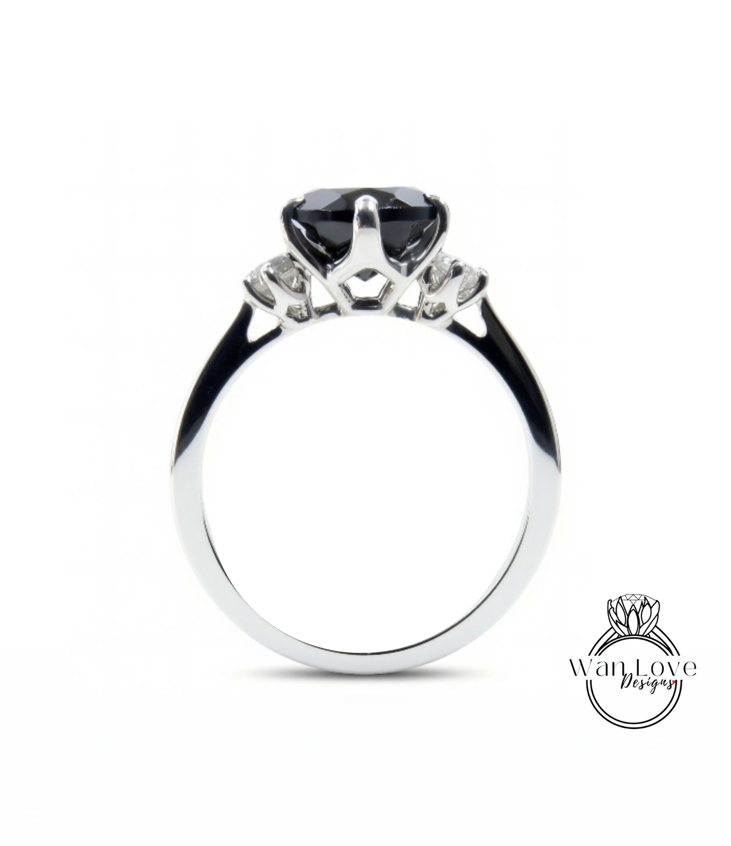 A silver engagement ring with a large black gemstone, possibly a diamond, set in the center.