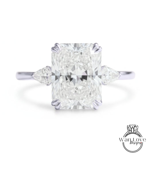 A large, brilliant-cut diamond engagement ring with a prominent central diamond surrounded by smaller diamonds on either side.