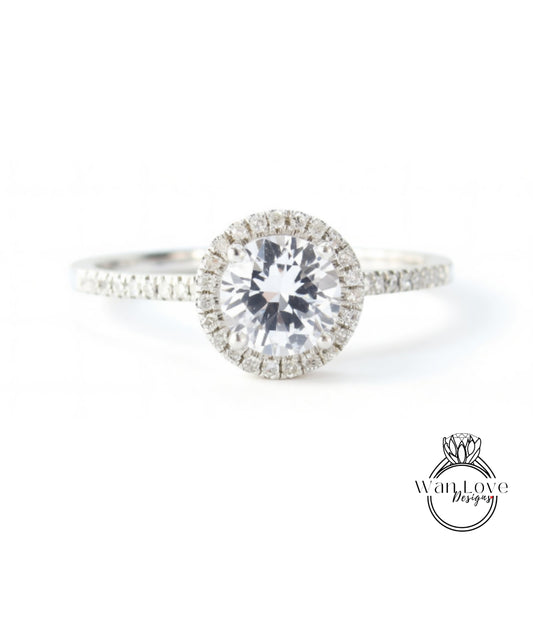 A close-up view of a diamond engagement ring with a large central diamond surrounded by smaller diamonds on the band.