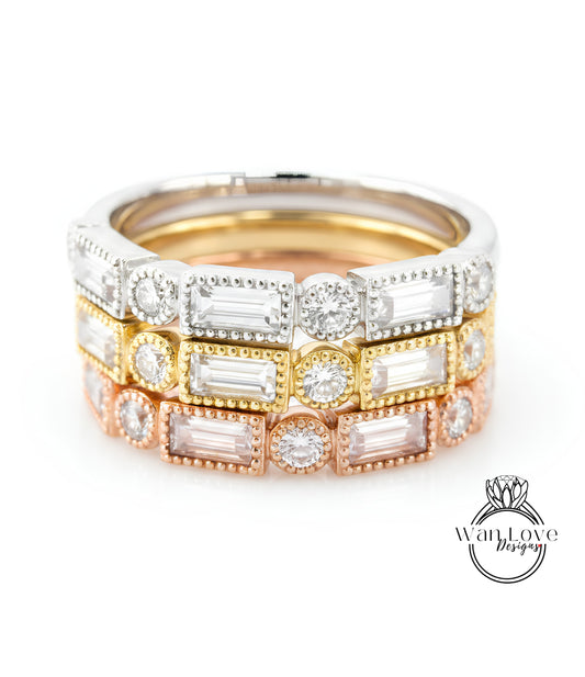 A close-up image of a stack of rings with various colored gemstones, including clear, white, and multicolored stones.