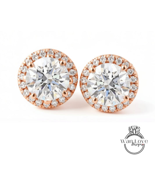 A pair of elegant earrings with large, clear diamonds set in a halo of smaller diamonds, all encircled by a thin gold band.